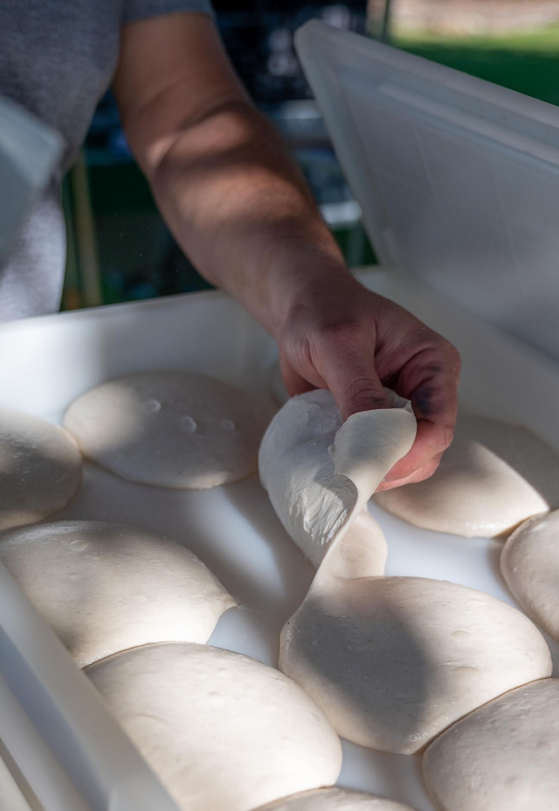 Pizza dough being hand-stretched