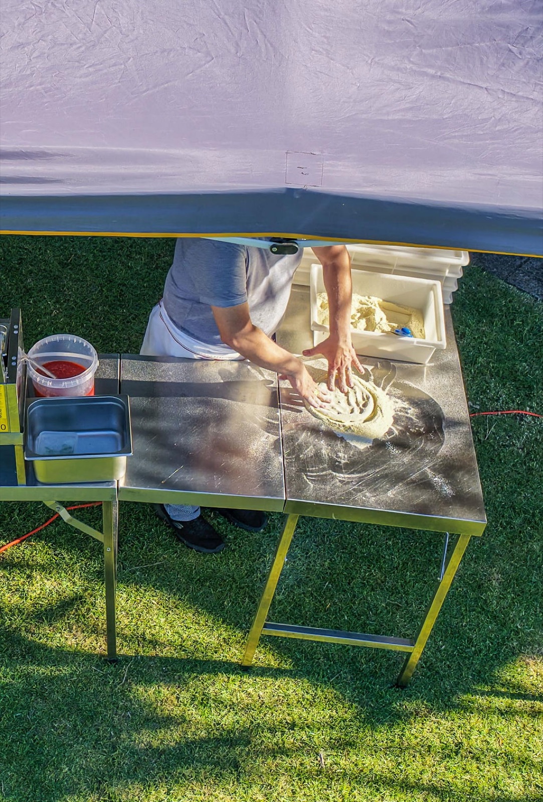 Pizzaiolo working pizza dough at the truck